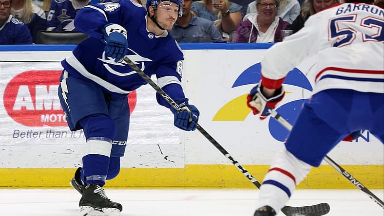 Mar 18, 2023; Tampa, Florida, USA;Tampa Bay Lightning left wing Tanner Jeannot (84) passes the puck as Montreal Canadiens defenseman Justin Barron (52) defends during the first period at Amalie Arena. Mandatory Credit: Kim Klement-USA TODAY Sports