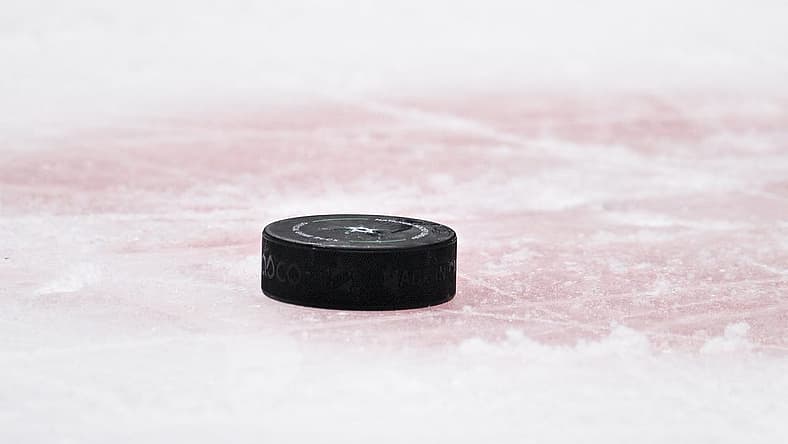 Apr 17, 2023; Dallas, Texas, USA; A view of a NHL hockey puck and the red face-off circle during the game between the Dallas Stars and the Minnesota Wild in game one of the first round of the 2023 Stanley Cup Playoffs at the American Airlines Center. Mandatory Credit: Jerome Miron-USA TODAY Sports