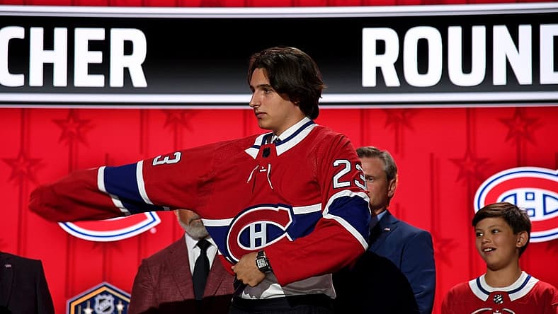 Jun 28, 2023; Nashville, Tennessee, USA; Montreal Canadiens draft pick David Reinbacher puts on his sweater after being selected with the fifth pick in round one of the 2023 NHL Draft at Bridgestone Arena. Mandatory Credit: Christopher Hanewinckel-USA TODAY Sports