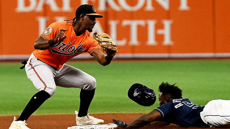 Jul 22, 2023; St. Petersburg, Florida, USA; Tampa Bay Rays left fielder Randy Arozarena (56) lies as Baltimore Orioles short stop Jorge Mateo (3) attempts to place the tag in the eighth inning at Tropicana Field. Mandatory Credit: Jonathan Dyer-USA TODAY Sports