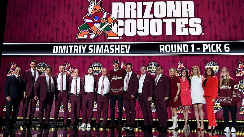 Jun 28, 2023; Nashville, Tennessee, USA; Arizona Coyotes draft pick Dmitriy Simashev stands with Coyotes staff after being selected with the sixth pick in round one of the 2023 NHL Draft at Bridgestone Arena. Mandatory Credit: Christopher Hanewinckel-USA TODAY Sports