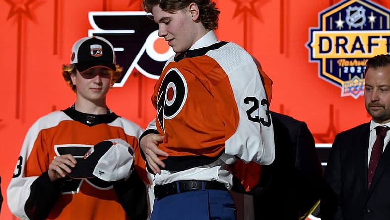 Jun 28, 2023; Nashville, Tennessee, USA; Philadelphia Flyers draft pick Oliver Bonk puts on his sweater after being selected with the twenty second pick in round one of the 2023 NHL Draft at Bridgestone Arena. Mandatory Credit: Christopher Hanewinckel-USA TODAY Sports