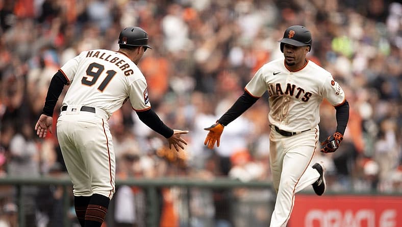 Aug 3, 2023; San Francisco, California, USA; San Francisco Giants first baseman LaMonte Wade Jr. (right) gets a congratulatory handshake from third base coach Mark Hallberg (91) after hitting a solo home run off Arizona Diamondbacks starting pitcher Brandon Pfaadt during the fourth inning at Oracle Park. Mandatory Credit: D. Ross Cameron-USA TODAY Sports