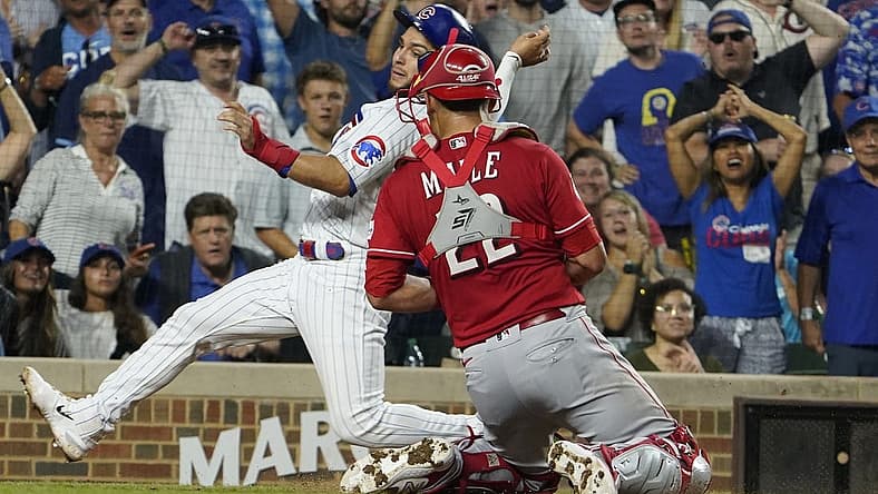 Aug 3, 2023; Chicago, Illinois, USA; Cincinnati Reds catcher Luke Maile (22) tags out Chicago Cubs third baseman Nick Madrigal (1) during the fourth inning at Wrigley Field. Mandatory Credit: David Banks-USA TODAY Sports