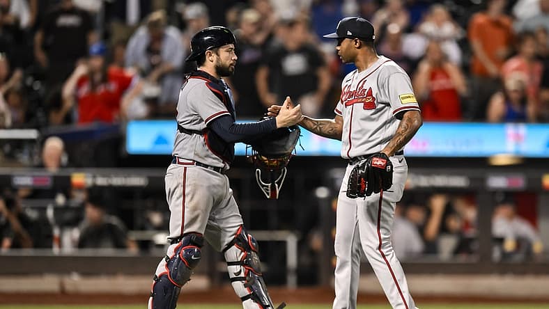 Aug 12, 2023; New York City, New York, USA; Atlanta Braves catcher Travis d'Arnaud (16) and Atlanta Braves relief pitcher Raisel Iglesias (26) shake hands after winning 6-0 against the New York Mets at Citi Field. Mandatory Credit: John Jones-USA TODAY Sports