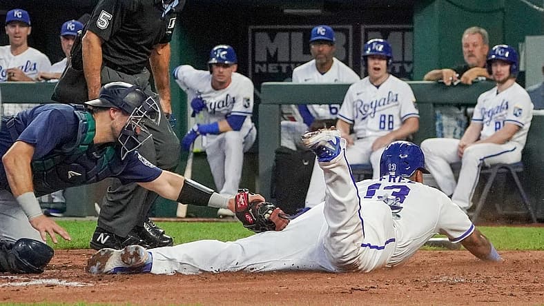 Aug 16, 2023; Kansas City, Missouri, USA; Seattle Mariners catcher Cal Raleigh (29) misses the tag as Kansas City Royals catcher Salvador Perez (13) scores in the third inning at Kauffman Stadium. Mandatory Credit: Denny Medley-USA TODAY Sports