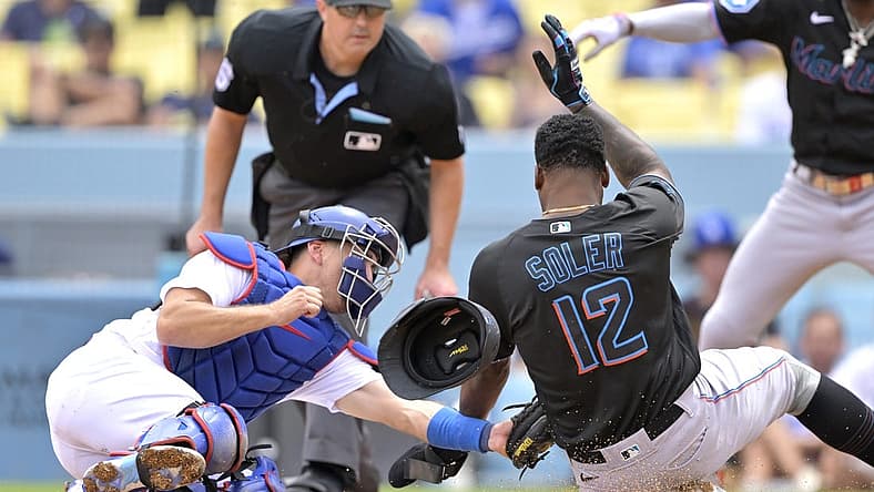 Aug 19, 2023; Los Angeles, California, USA;  Los Angeles Dodgers catcher Austin Barnes (15) tags Miami Marlins designated hitter Jorge Soler (12) out at home on a throw by Los Angeles Dodgers right fielder David Peralta (6) in the third inning at Dodger Stadium. Mandatory Credit: Jayne Kamin-Oncea-USA TODAY Sports