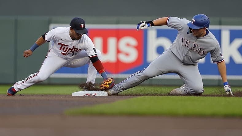 Aug 25, 2023; Minneapolis, Minnesota, USA; Texas Rangers shortstop Corey Seager (5) beats the tag of Minnesota Twins second baseman Jorge Polanco (11) for a double in the first inning at Target Field. Mandatory Credit: Bruce Kluckhohn-USA TODAY Sports