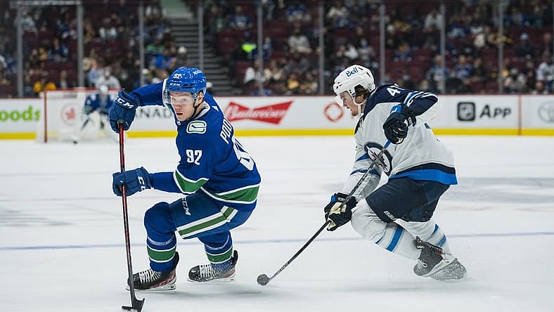 Oct 3, 2021; Vancouver, British Columbia, CAN;  Winnipeg Jets defenseman Declan Chisholm (47) checks Vancouver Canucks forward Vasily Podkolzin (92) in the second period at Rogers Arena. Mandatory Credit: Bob Frid-USA TODAY Sports