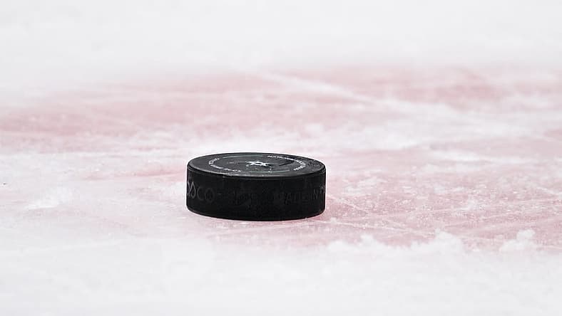 Apr 17, 2023; Dallas, Texas, USA; A view of a NHL hockey puck and the red face-off circle during the game between the Dallas Stars and the Minnesota Wild in game one of the first round of the 2023 Stanley Cup Playoffs at the American Airlines Center. Mandatory Credit: Jerome Miron-USA TODAY Sports