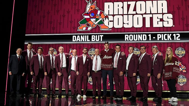 Jun 28, 2023; Nashville, Tennessee, USA; Arizona Coyotes draft pick Daniil But stands with Coyotes staff after being selected with the twelfth pick in round one of the 2023 NHL Draft at Bridgestone Arena. Mandatory Credit: Christopher Hanewinckel-USA TODAY Sports