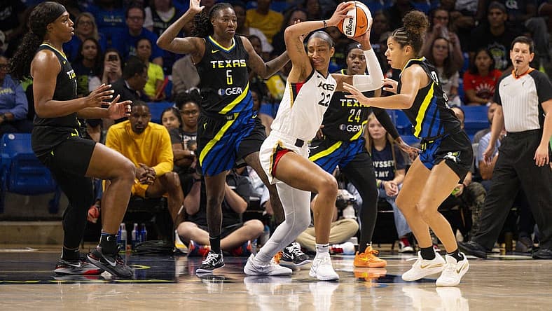 Sep 29, 2023; Arlington, Texas, USA; Las Vegas Aces forward A'ja Wilson (22) looks to move the ball past Dallas Wings forward Natasha Howard (6) and guard Arike Ogunbowale (24) and center Teaira McCowan (7) during the first half during game three of the 2023 WNBA Playoffs at College Park Center. Mandatory Credit: Jerome Miron-USA TODAY Sports