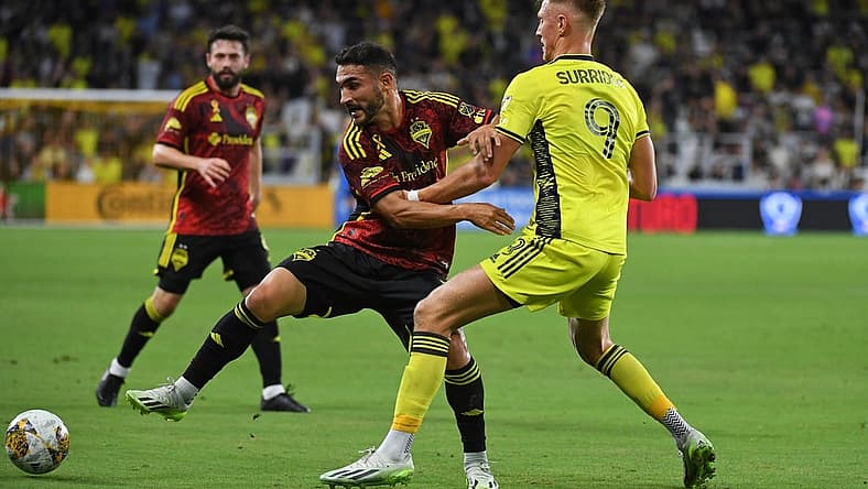 Sep 30, 2023; Nashville, Tennessee, USA; Seattle Sounders FC midfielder Cristian Roldan (7) plays the ball against Nashville SC forward Sam Surridge (9) during the first half at Geodis Park. Mandatory Credit: Christopher Hanewinckel-USA TODAY Sports