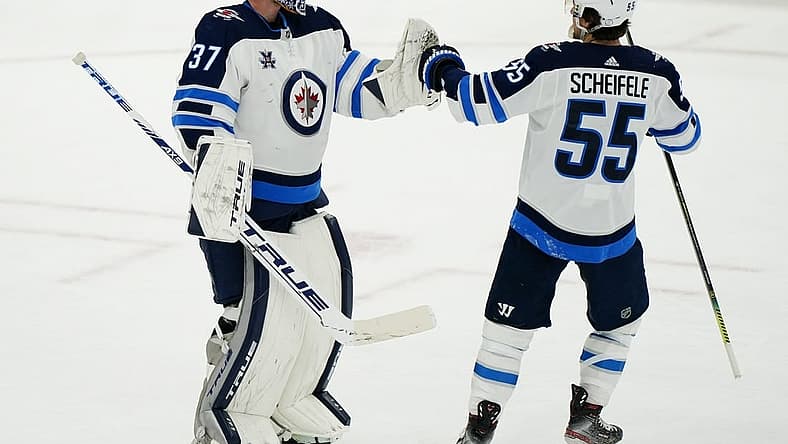Apr 15, 2021; Toronto, Ontario, CAN; Winnipeg Jets forward Mark Scheifele (55) congratulates goaltender Connor Hellebuyck (37) on a win over the Toronto Maple Leafs during the third period at Scotiabank Arena. Mandatory Credit: John E. Sokolowski-USA TODAY Sports