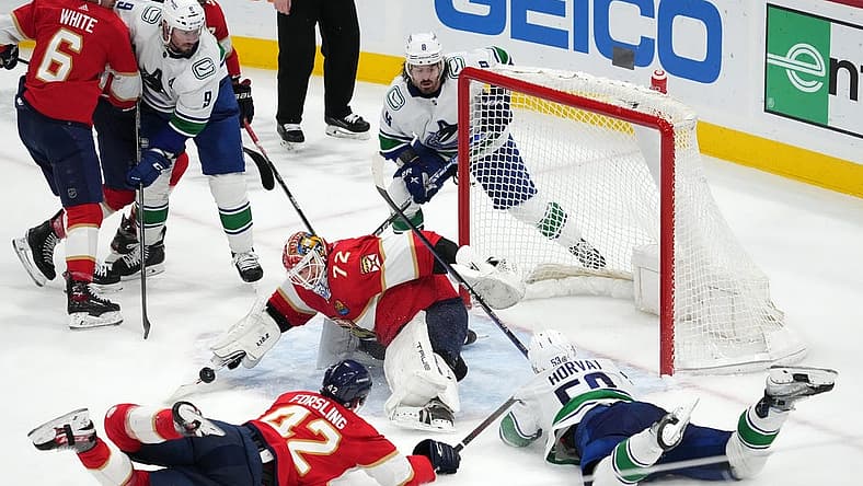 Jan 14, 2023; Sunrise, Florida, USA; Florida Panthers goaltender Sergei Bobrovsky (72) makes a save in front of defenseman Gustav Forsling (42) and Vancouver Canucks center Bo Horvat (53) during the third period at FLA Live Arena. Mandatory Credit: Jasen Vinlove-USA TODAY Sports