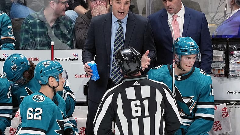 Mar 11, 2023; San Jose, California, USA; San Jose Sharks head coach David Quinn (center) talks to linesman James Tobias (61) during the third period against the Minnesota Wild at SAP Center at San Jose. Mandatory Credit: Darren Yamashita-USA TODAY Sports