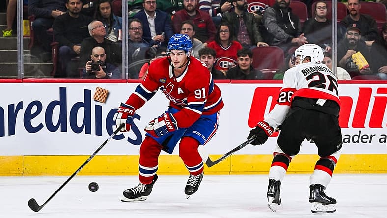 Sep 27, 2023; Montreal, Quebec, CAN; Montreal Canadiens center Sean Monahan (91) plays the puck against Ottawa Senators defenseman Erik Brannstrom (26) during the second period at Bell Centre. Mandatory Credit: David Kirouac-USA TODAY Sports