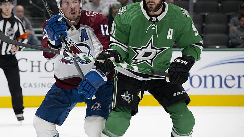 Oct 3, 2023; Dallas, Texas, USA; Colorado Avalanche center Ryan Johansen (12) and Dallas Stars center Tyler Seguin (91) battle for position in the Stars zone during the first period at the American Airlines Center. Mandatory Credit: Jerome Miron-USA TODAY Sports