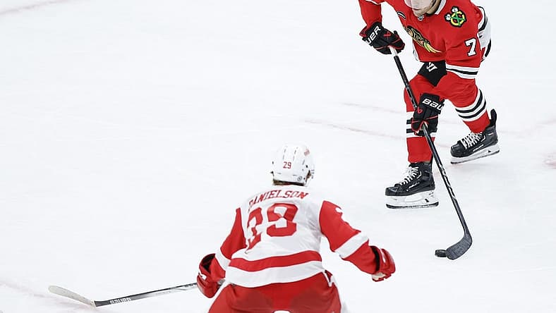 Oct 3, 2023; Chicago, Illinois, USA; Chicago Blackhawks forward Taylor Hall (71) passes the puck against Detroit Red Wings forward Nate Danielson (29) during the third period of a preseason hockey game at United Center. Mandatory Credit: Kamil Krzaczynski-USA TODAY Sports