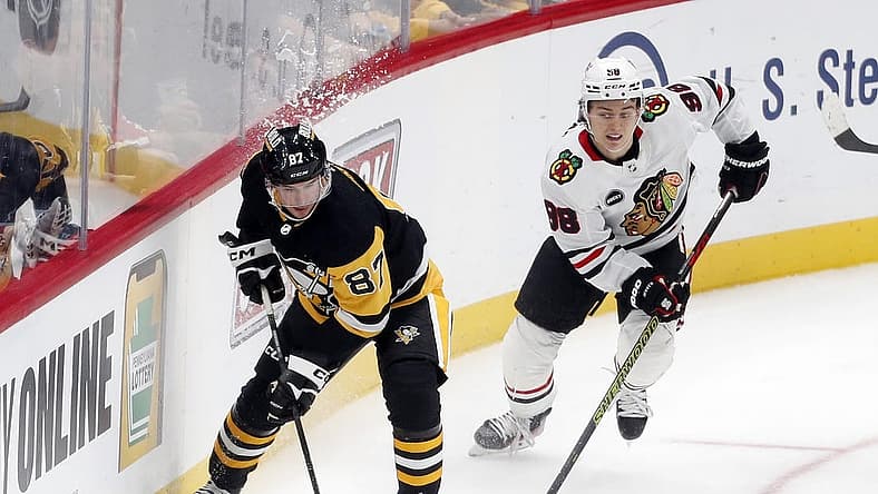 Oct 10, 2023; Pittsburgh, Pennsylvania, USA; Pittsburgh Penguins center Sidney Crosby (87) moves the puck ahead of Chicago Blackhawks center Connor Bedard (98) during the second period at the PPG Paints Arena. Chicago won 4-2. Mandatory Credit: Charles LeClaire-USA TODAY Sports