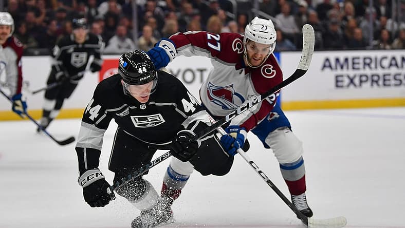 Oct 11, 2023; Los Angeles, California, USA; Colorado Avalanche left wing Jonathan Drouin (27) plays for the puck against Los Angeles Kings defenseman Mikey Anderson (44) during the first period at Crypto.com Arena. Mandatory Credit: Gary A. Vasquez-USA TODAY Sports