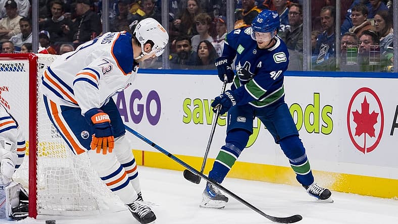 Oct 11, 2023; Vancouver, British Columbia, CAN; Vancouver Canucks forward Elias Pettersson (40) passes the puck behind Edmonton Oilers defenseman Vincent Desharnais (73) in the first period at Rogers Arena. Mandatory Credit: Bob Frid-USA TODAY Sports