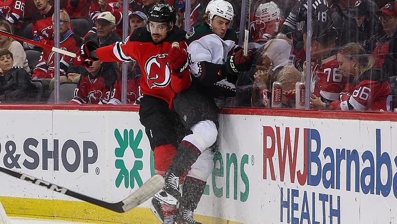 Oct 13, 2023; Newark, New Jersey, USA; New Jersey Devils defenseman Kevin Bahl (88) hits Arizona Coyotes center Logan Cooley (92) during the first period at Prudential Center. Mandatory Credit: Ed Mulholland-USA TODAY Sports