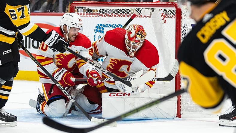 Oct 14, 2023; Pittsburgh, Pennsylvania, USA; Calgary Flames goalie Jacob Markstrom (25) makes a save with help from center Blake Coleman (20) on a shot by Pittsburgh Penguins center Sidney Crosby (87) during the first period at PPG Paints Arena. Mandatory Credit: Scott Galvin-USA TODAY Sports
