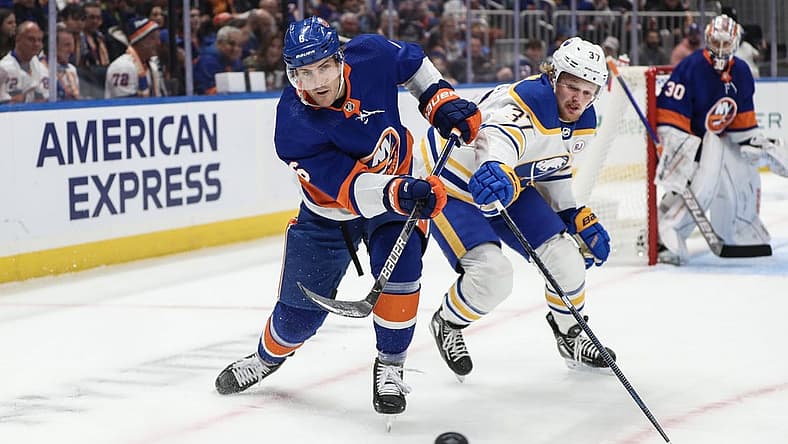 Oct 14, 2023; Elmont, New York, USA; New York Islanders defenseman Ryan Pulock (6) and Buffalo Sabres center Casey Mittelstadt (37) battle for control of the puck in the first period at UBS Arena. Mandatory Credit: Wendell Cruz-USA TODAY Sports