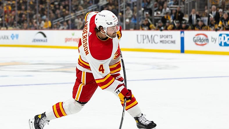 Oct 14, 2023; Pittsburgh, Pennsylvania, USA; Calgary Flames defenseman Rasmus Andersson (4) takes a slapshot against the Pittsburgh Penguins during the second period at PPG Paints Arena. Mandatory Credit: Scott Galvin-USA TODAY Sports
