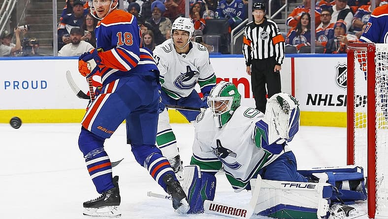 Oct 14, 2023; Edmonton, Alberta, CAN; Edmonton Oilers forward Zach Hyman (18) and Vancouver Canucks goaltender Casey DeSmith (29) look for a loose puck during the first period at Rogers Place. Mandatory Credit: Perry Nelson-USA TODAY Sports