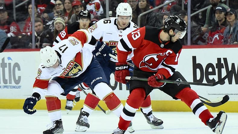 Oct 16, 2023; Newark, New Jersey, USA; Florida Panthers center Evan Rodrigues (17) tries to gain control of the puck against the New Jersey Devils during the first period at Prudential Center. Mandatory Credit: John Jones-USA TODAY Sports