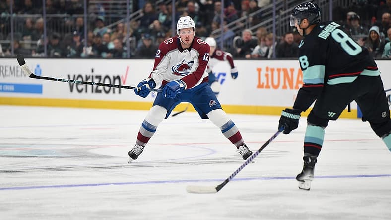 Oct 17, 2023; Seattle, Washington, USA; Colorado Avalanche center Ryan Johansen (12) defends Seattle Kraken defenseman Brian Dumoulin (8) during the first period at Climate Pledge Arena. Mandatory Credit: Steven Bisig-USA TODAY Sports
