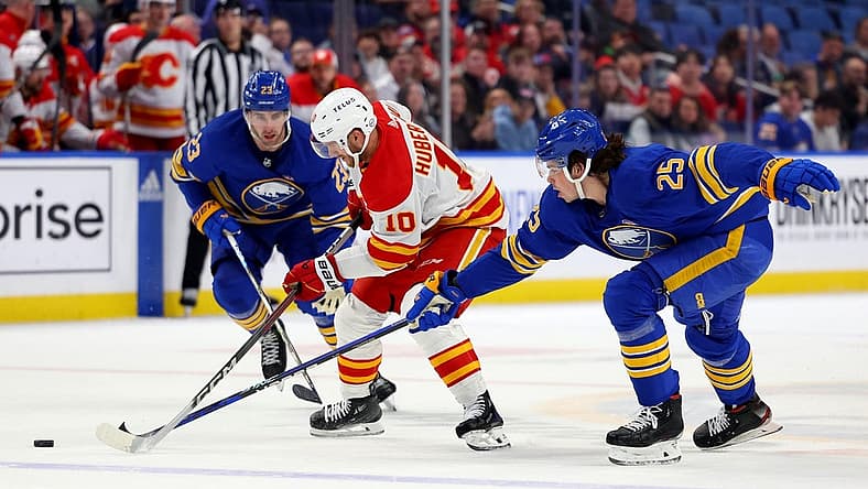 Oct 19, 2023; Buffalo, New York, USA; Buffalo Sabres defenseman Owen Power (25) knocks the puck off the stick of Calgary Flames center Jonathan Huberdeau (10) during the first period at KeyBank Center. Mandatory Credit: Timothy T. Ludwig-USA TODAY Sports