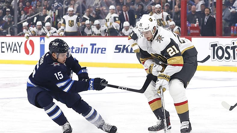 Oct 19, 2023; Winnipeg, Manitoba, CAN; Winnipeg Jets center Rasmus Kupari (15) checks Vegas Golden Knights center Brett Howden (21) in the first period at Canada Life Centre. Mandatory Credit: James Carey Lauder-USA TODAY Sports
