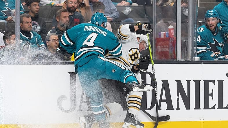 Oct 19, 2023; San Jose, California, USA; San Jose Sharks defenseman Kyle Burroughs (4) collides into Boston Bruins left wing Brad Marchand (63) during the first period at SAP Center at San Jose. Mandatory Credit: Stan Szeto-USA TODAY Sports