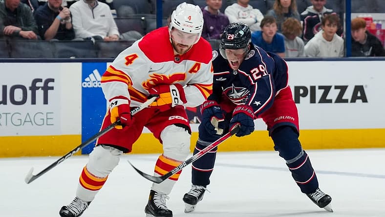 Oct 20, 2023; Columbus, Ohio, USA; Calgary Flames defenseman Rasmus Andersson (4) skates with the puck against Columbus Blue Jackets right wing Patrik Laine (29) in the third period at Nationwide Arena. Mandatory Credit: Aaron Doster-USA TODAY Sports