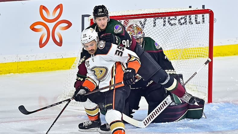 Oct 21, 2023; Tempe, Arizona, USA;  Anaheim Ducks center Sam Carrick (39) and Arizona Coyotes defenseman J.J. Moser (90) battle for position in front of goaltender Karel Vejmelka (70) in the first period at Mullett Arena. Mandatory Credit: Matt Kartozian-USA TODAY Sports