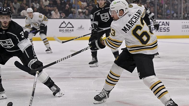 Oct 21, 2023; Los Angeles, California, USA; Boston Bruins left wing Brad Marchand (63) shoots against Los Angeles Kings defenseman Matt Roy (3) during the first period at Crypto.com Arena. Mandatory Credit: Alex Gallardo-USA TODAY Sports