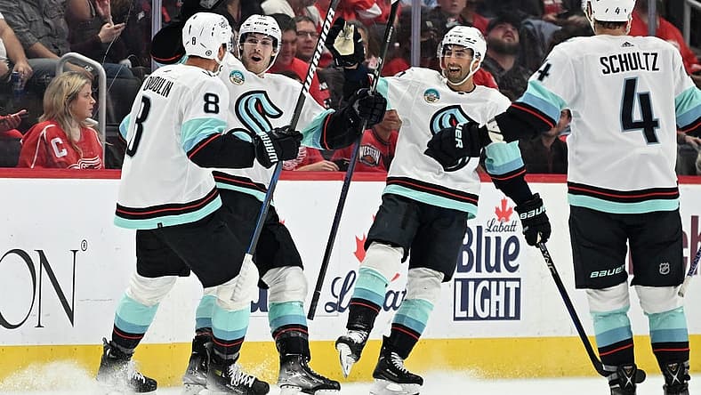 Oct 24, 2023; Detroit, Michigan, USA; Seattle Kraken defenseman Brian Dumoulin (8) celebrates with Seattle Kraken left wing Tye Kartye (52) (center left) right wing Jordan Eberle (7) (center right) and defenseman Justin Schultz (4) after the Kraken scored a goal against the Detroit Red Wings in the second period at Little Caesars Arena. Mandatory Credit: Lon Horwedel-USA TODAY Sports