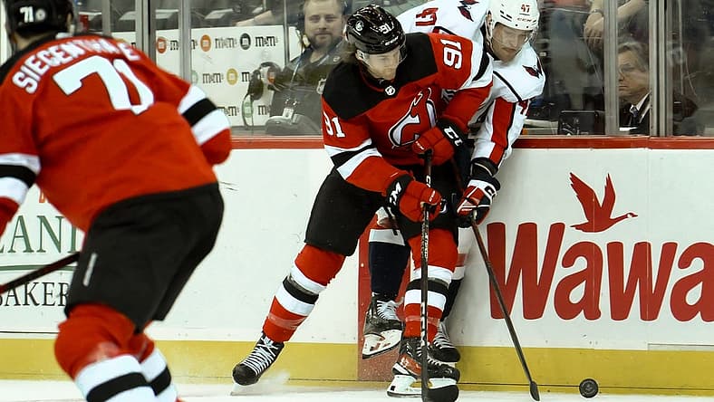 Oct 25, 2023; Newark, New Jersey, USA; New Jersey Devils center Dawson Mercer (91) checks Washington Capitals left wing Beck Malenstyn (47) during the first period at Prudential Center. Mandatory Credit: John Jones-USA TODAY Sports