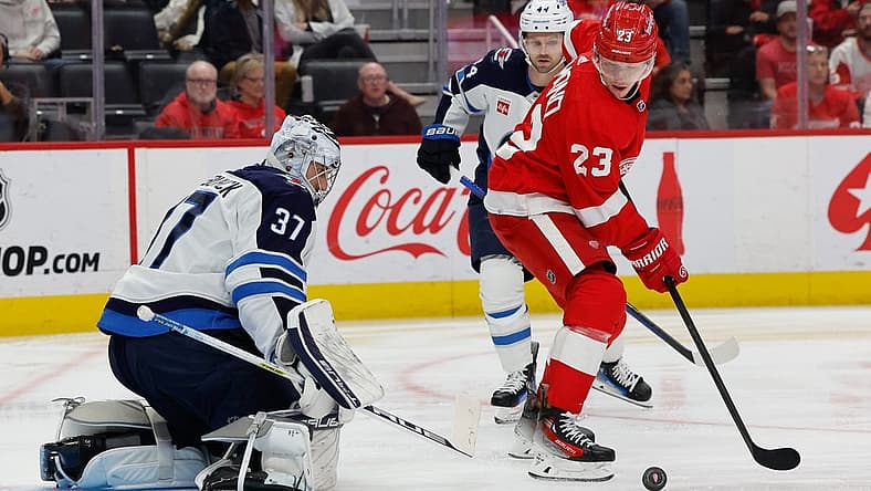 Oct 26, 2023; Detroit, Michigan, USA; Winnipeg Jets goaltender Connor Hellebuyck (37) makes the save in front of Detroit Red Wings left wing Lucas Raymond (23) in the second period at Little Caesars Arena. Mandatory Credit: Rick Osentoski-USA TODAY Sports
