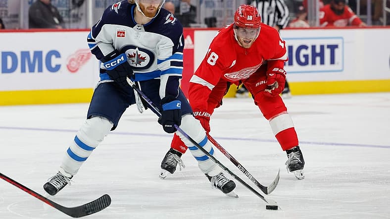 Oct 26, 2023; Detroit, Michigan, USA;  Winnipeg Jets left wing Kyle Connor (81) skates with the puck chased by Detroit Red Wings center Andrew Copp (18) in the third period at Little Caesars Arena. Mandatory Credit: Rick Osentoski-USA TODAY Sports