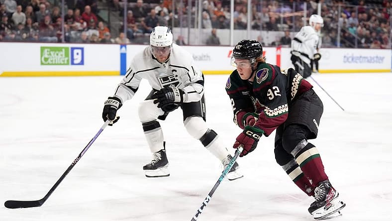 Oct 27, 2023; Tempe, Arizona, USA; Arizona Coyotes center Logan Cooley (92) skates against Los Angeles Kings center Anze Kopitar (11) during the first period at Mullett Arena. Mandatory Credit: Joe Camporeale-USA TODAY Sports