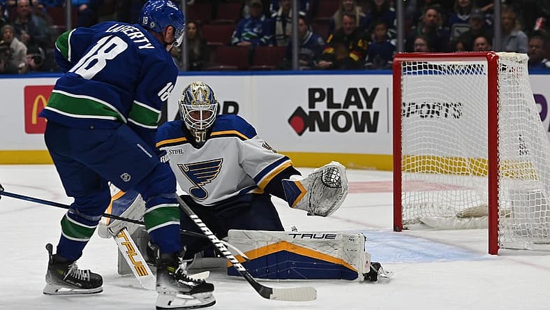 Oct 27, 2023; Vancouver, British Columbia, CAN; Vancouver Canucks forward Sam Lafferty (18) drives the net towards St. Louis Blues goaltender Jordan Binnington (50) during the first period at Rogers Arena. Mandatory Credit: Simon Fearn-USA TODAY Sports