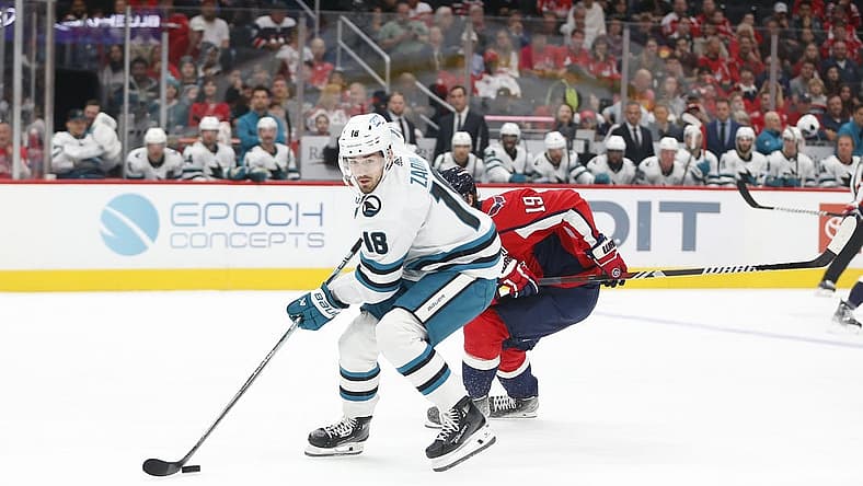 Oct 29, 2023; Washington, District of Columbia, USA; San Jose Sharks right wing Filip Zadina (18) controls the puck in front of Washington Capitals center Nicklas Backstrom (19) during the first period at Capital One Arena. Mandatory Credit: Amber Searls-USA TODAY Sports