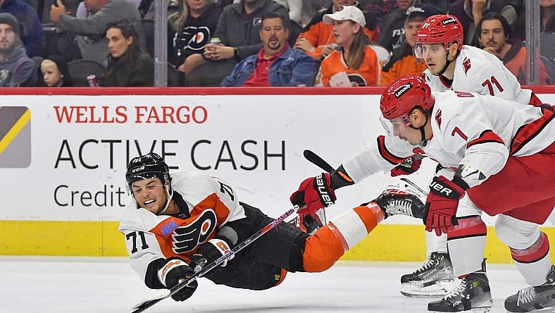Oct 30, 2023; Philadelphia, Pennsylvania, USA; Philadelphia Flyers right wing Tyson Foerster (71) passes the puck while being untended by Carolina Hurricanes right wing Jesper Fast (71) and defenseman Dmitry Orlov (7) during the first period at Wells Fargo Center. Mandatory Credit: Eric Hartline-USA TODAY Sports