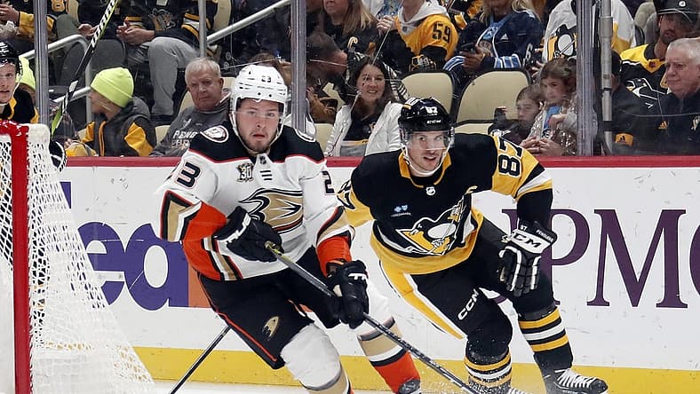 Oct 30, 2023; Pittsburgh, Pennsylvania, USA; Anaheim Ducks center Mason McTavish (23) skates with the puck ahead of Pittsburgh Penguins center Sidney Crosby (87) during the first period at PPG Paints Arena. Mandatory Credit: Charles LeClaire-USA TODAY Sports