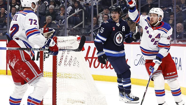 Oct 30, 2023; Winnipeg, Manitoba, CAN; New York Rangers left wing Artemi Panarin (10) celebrates his first period goal with center Filip Chytil (72) as Winnipeg Jets center Mark Scheifele (55) looks on in the first period at Canada Life Centre. Mandatory Credit: James Carey Lauder-USA TODAY Sports