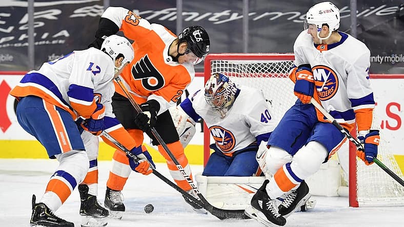 Jan 30, 2021; Philadelphia, Pennsylvania, USA; Philadelphia Flyers left wing Oskar Lindblom (23) battles for the puck with New York Islanders left wing Matt Martin (17) and defenseman Adam Pelech (3) in front of goaltender Semyon Varlamov (40) during the second period at Wells Fargo Center. Mandatory Credit: Eric Hartline-USA TODAY Sports